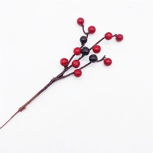 Detail of faux Christmas berry spray with red and black berries on a white background