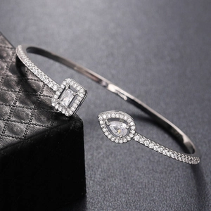 Detail of silver open cuff bracelet with rectangular and teardrop cubic zirconia inlay
