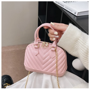 Pink jelly mini handbag detail with golden metal chain and glossy PVC texture finish