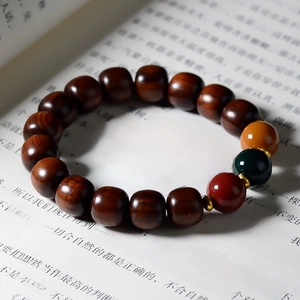 Macro detail of sandalwood beads with colorful accents on a Chinese book background