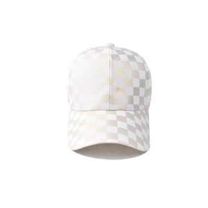 Macro shot of white and gold checkered pattern fabric on a satin baseball cap crown