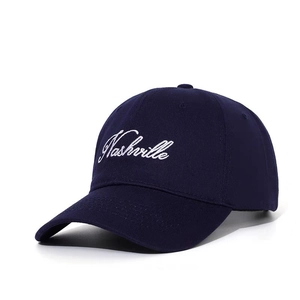Detail of Nashville embroidery on navy blue cotton baseball cap with white script lettering