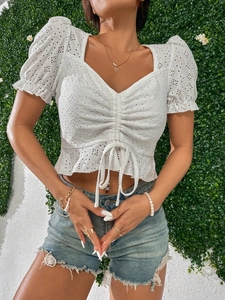 Top court blanc en dentelle anglaise avec col en V, cordon de serrage et manches bouffantes