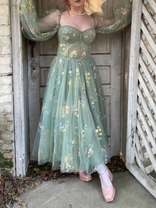 Detail of sage green puff sleeves and colorful floral embroidery on mesh evening gown