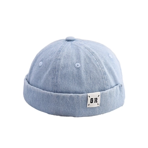 Detail of light blue vintage docker cap with GR logo patch and twill cotton texture