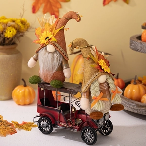 Détail de gnomes d'automne avec feuilles d'érable et tournesols sur un camion vintage rouge