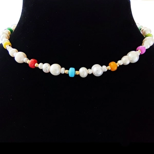 Detailed close-up of Baroque pearl necklace with colorful beads on black neck model