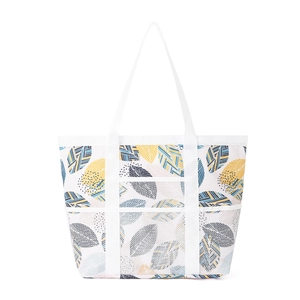 Detail von buntem Blattmuster und Netztaschen an einer großen Reise-Strandtasche