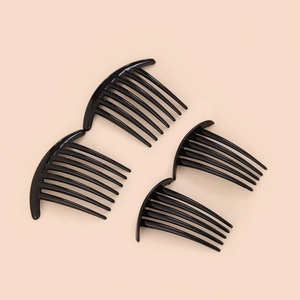 Macro shot of four black plastic hair side combs on a clean beige background