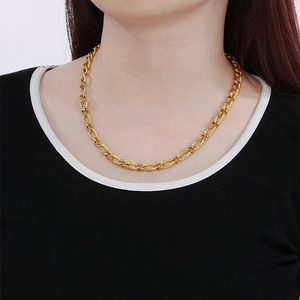 Primo piano di una collana a catena 3:1 NK dorata indossata che mostra la trama