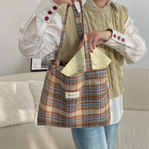 Detail of blue and brown plaid wool tote bag showing large capacity and label