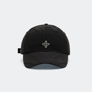 Détail d'une casquette noire en tissu technique avec broderie florale et visière cousue