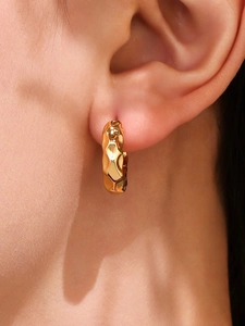 Vue macro détaillée de la boucle d'oreille créole plaquée or 18 carats avec texture martelée