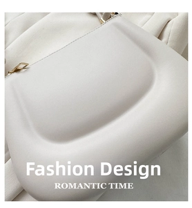 Detail of a creamy beige leather saddle bag with refined gold buckle and soft texture