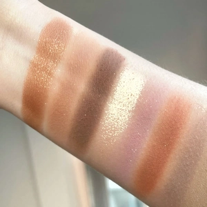 Arm swatches showing six matte and shimmer eyeshadow shades from the 26-color makeup palette
