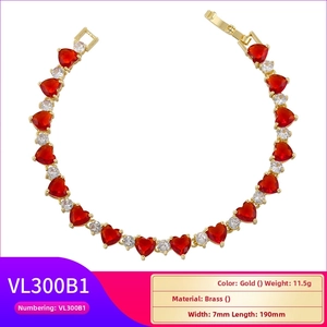 Detail of gold brass bracelet featuring ruby red heart stones and round white zircons
