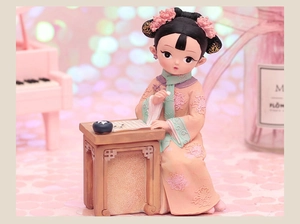 Detail of cute resin girl figurine in pink Hanfu playing Go at a miniature table