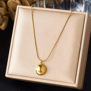 Polished gold ball pendant necklace with sleek snake chain in luxury gift box display