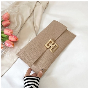 Detail of beige crocodile pattern clutch bag featuring a gold rectangular metal buckle