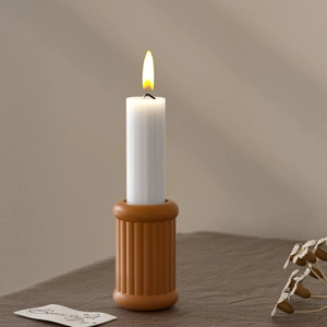Artistic fluted pillar candle holder in terracotta resin with a white candle