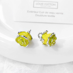 Macro detail of yellow rose-shaped enamel charms for DIY jewelry and necklaces