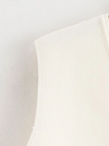 Gros plan du débardeur en maille crème montrant la texture fine et les détails du col