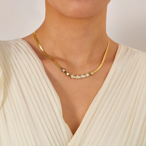 Détail du collier chaîne serpent plaqué or 18K avec sept petits pendentifs étoiles blanches