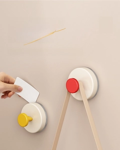 Removing suction cup hook with a white card to demonstrate its damage-free feature