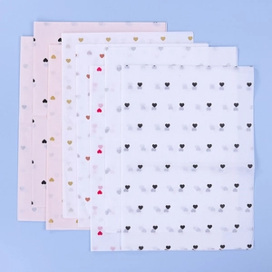 Detail of pink and white tissue paper with small heart patterns for bouquet wrapping