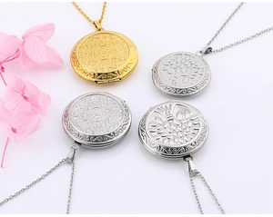 Detailed view of heart locket pendants with tree of life and mandala flower engravings