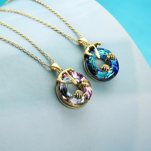 Golden bee crystal necklace with blue and pink gradient pendants in a geometric setting