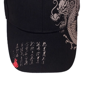Close-up of intricate dragon embroidery and Chinese characters on a black baseball cap