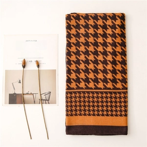 Close-up of vintage houndstooth scarf with warm orange and brown knit texture