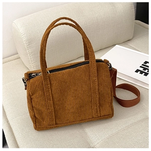 Detailed texture of brown corduroy Boston bag with sturdy handles and metal zipper