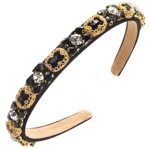 Close-up of luxury vintage headband featuring black faceted gems and gold metal details