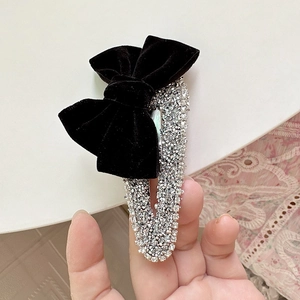 Close-up of velvet bow hair clip with sparkling silver rhinestones for elegant styling
