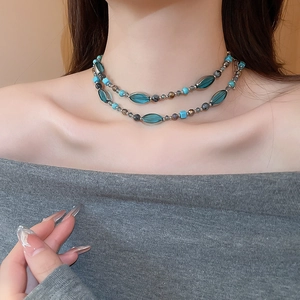 Gros plan d'un collier à double rangée de perles turquoise avec une chaîne ajustable