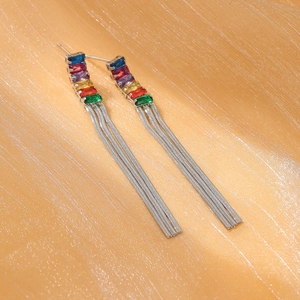 Fashionable titanium steel tassel earrings with colorful rhinestones on silk background