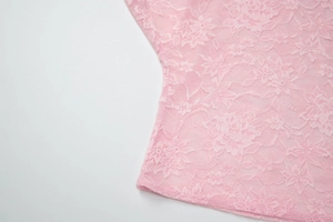 Primer plano de la tela de encaje rosa con detalles florales y textura transparente