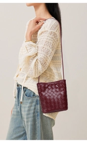 Gros plan du sac seau tressé bordeaux montrant la texture du cuir et le savoir-faire