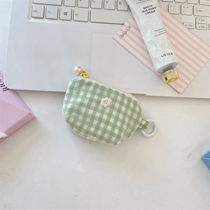 Mini gingham coin purse with floral embroidery and pearl zipper detail on desk