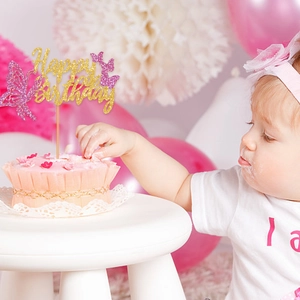 Pink and gold Happy Birthday butterfly cake topper at a festive first birthday party