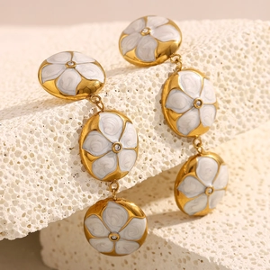 Detail von 18K vergoldeten Ohrringen mit weißen Emaille-Blumen und Kristallakzenten