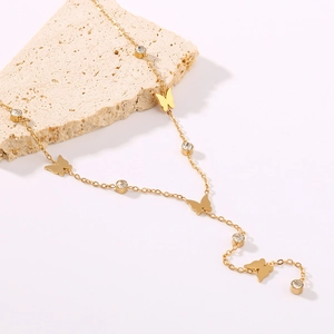 18K gold plated butterfly necklace with sparkling crystals on a textured stone
