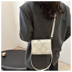 Dettaglio della borsa trapuntata beige con hardware dorato e motivo a rombi