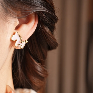 Detail of 18K gold plated pony earring with pink enamel and a gold heart accent