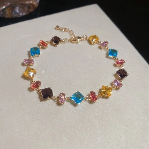 Elegantes goldfarbenes Armband mit lebhaften bunten geometrischen Zirkonia in einer Detailansicht.