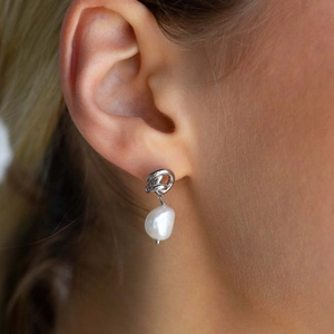 Elegant 18K gold plated earrings with white baroque pearls shown on a model