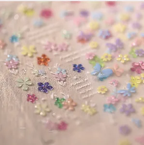 Macro shot of 3D embossed floral and butterfly nail stickers with rich macaron textures