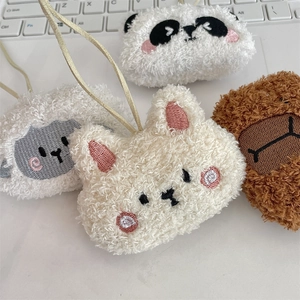 Dettaglio di portachiavi in peluche di animali ricamati su tastiera di laptop